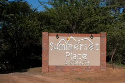a sign for a summer resort place with trees in the background at Summerset Place Country House in Bela-Bela