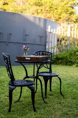 a table and two chairs with a table and flowers at Schimper View Boutique Guest House in Louis Trichardt
