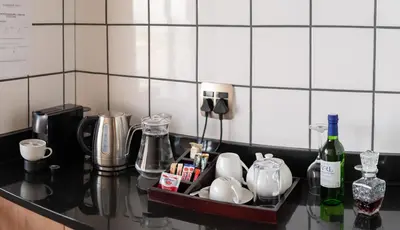 a kitchen counter with a tray with dishes and wine bottles at Schimper View Boutique Guest House in Louis Trichardt