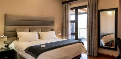 a bedroom with a large bed and a mirror at Schimper View Boutique Guest House in Louis Trichardt