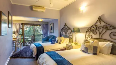 a hotel room with two beds and a balcony at Jörn's Gästehaus in Nelspruit