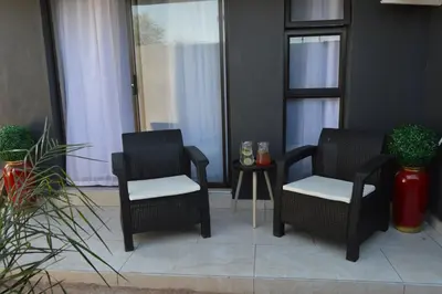 two black chairs and a table in a room at Clifford's Rufaro Hotel, Conference & Spa in Burgersfort