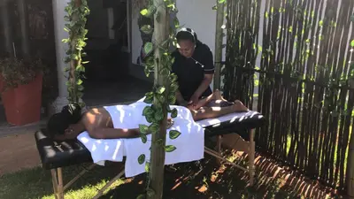 two men laying on beds in a gazebo at Clifford's Rufaro Hotel, Conference & Spa in Burgersfort