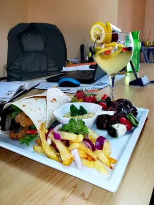 a plate of food with french fries and a drink at Clifford's Rufaro Hotel, Conference & Spa in Burgersfort