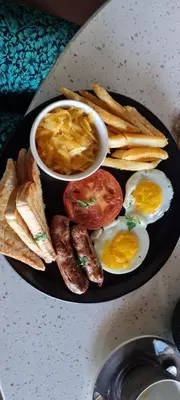 a black plate with eggs and toast and chips at Clifford's Rufaro Hotel, Conference & Spa in Burgersfort