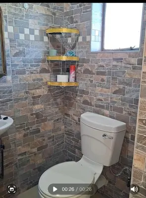 a bathroom with a toilet and a brick wall at Cosy Beds Web in Witbank