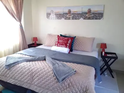 a bedroom with a large bed with pillows on it at Cosy Beds Web in Witbank