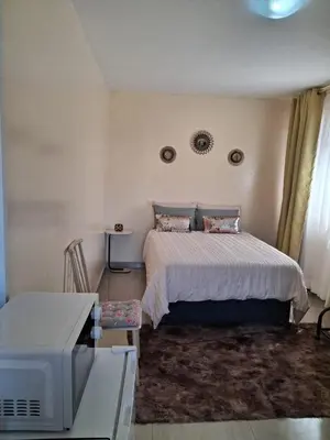 a bedroom with a bed and a tv in it at Cosy Beds Web in Witbank