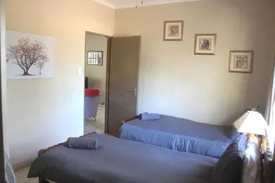 a bedroom with two beds and a mirror at Nature House in Marloth Park