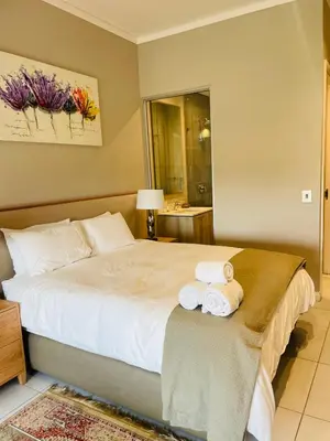 a bedroom with a bed with two towels on it at Menlyn Maine Trilogy Hotel in Pretoria