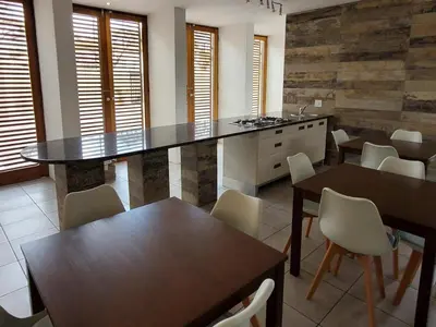 a kitchen with a counter and tables and chairs at Avonlea Guesthouse in Polokwane