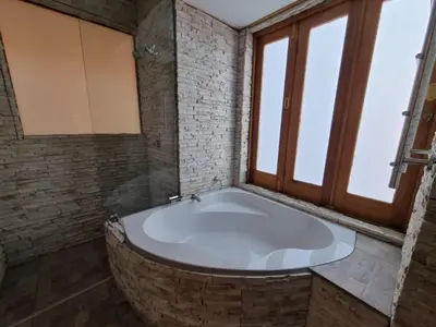 a large bath tub in a bathroom with windows at Avonlea Guesthouse in Polokwane