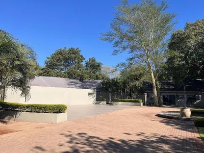 a building with trees and a brick driveway at Musina Hotel in Musina