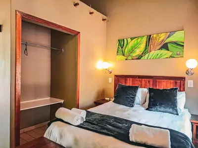 a bedroom with a large bed and a mirror at Musina Hotel in Musina
