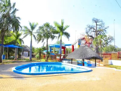 a swimming pool in a park with a playground at Sandriver Resort in Musina
