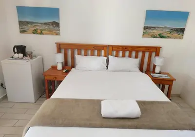 a bedroom with a large bed and two night stands at Sandriver Resort in Musina