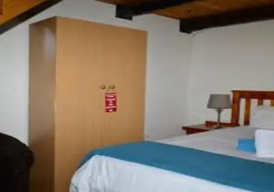 a bedroom with a bed with a wooden door at Sandriver Resort in Musina