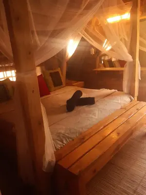 a wooden bed in a room with a canopy at African Bush Escape in Marloth Park