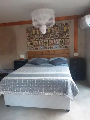 a bedroom with a bed with a blue comforter at African Bush Escape in Marloth Park