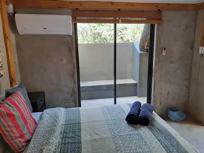 a bedroom with a bed with blue slippers on it at African Bush Escape in Marloth Park