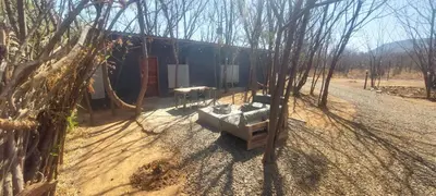 a house in the middle of a dirt road with trees at Vulture's View 1 in Hartbeespoort
