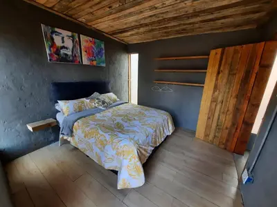 a bedroom with a bed and a wooden floor at Vulture's View 1 in Hartbeespoort