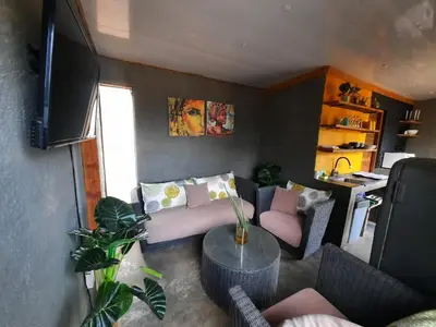 a living room with a couch and a table at Vulture's View 1 in Hartbeespoort