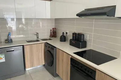 a kitchen with a sink and a dishwasher at The Blyde Silverlakes in Boschkop