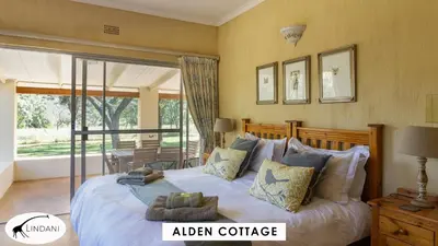 a bedroom with a large bed and a balcony at Lindani Game and Lodges in Vaalwater