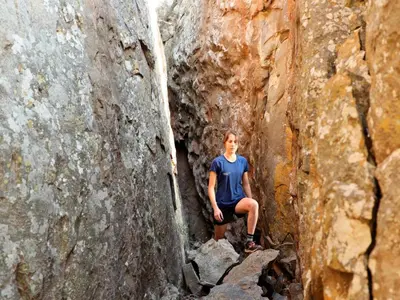 a man is sitting on a rock in a canyon at Lindani Game and Lodges in Vaalwater