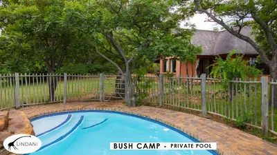 a fence around a small blue swimming pool in front of a house at Lindani Game and Lodges in Vaalwater