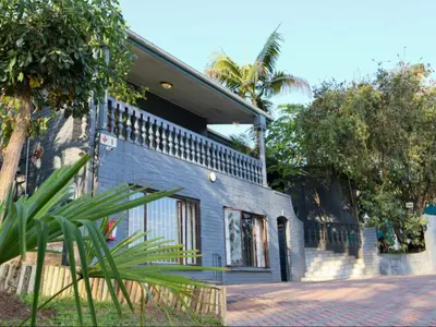 a blue house with a palm tree in front of it at Casa Palmeira in Nelspruit