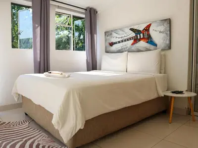 a bedroom with a large bed and a window at Casa Palmeira in Nelspruit