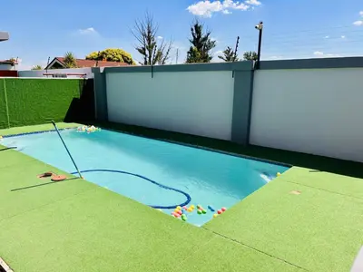 a small swimming pool with a white wall at Zindiza Guesthouse in Witbank