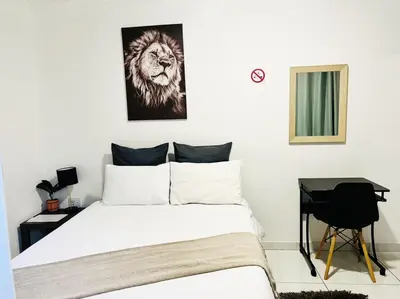 a bedroom with a bed with a lion picture on the wall at Zindiza Guesthouse in Witbank