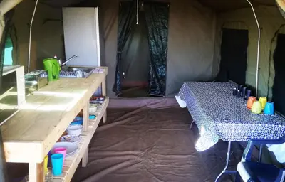 a tent with two tables and a table in it at Chosen Glamping Tents in Graskop