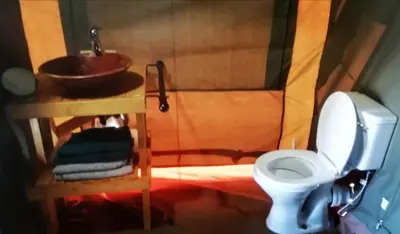 a small bathroom with a toilet and a sink at Chosen Glamping Tents in Graskop