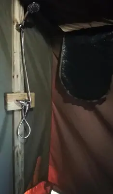 a lamp hanging on a wall next to a curtain at Chosen Glamping Tents in Graskop