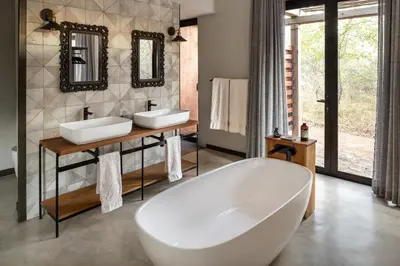 a bathroom with two sinks and a tub at Rixile Kruger Lodge in Skukuza