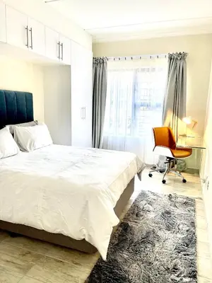 a bedroom with a bed and a desk and a chair at Ground Floor Apartment Midrand in Midrand