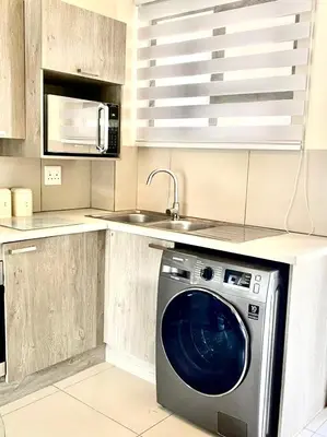 a kitchen with a washing machine and a sink at Ground Floor Apartment Midrand in Midrand
