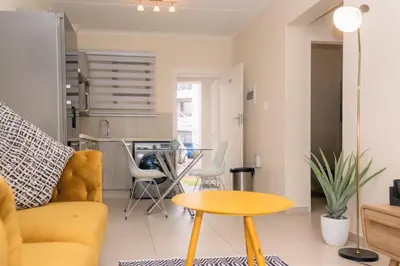 a living room with a yellow couch and a table at Ground Floor Apartment Midrand in Midrand