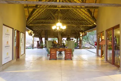 a room with a table and chairs and a chandelier at Kambaku River Sands in Timbavati Game Reserve