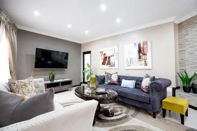 a living room with a couch and a tv at URlyfstyle 5 bedrooms 10km from OR Tambo Int Airport in Kempton Park