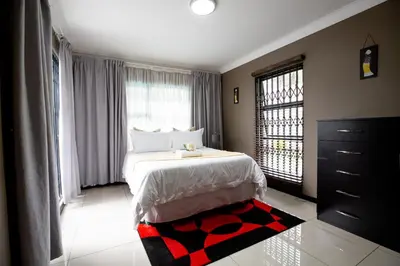 a bedroom with a bed and a large window at URlyfstyle 5 bedrooms 10km from OR Tambo Int Airport in Kempton Park