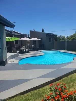 a swimming pool in a yard next to a house at URlyfstyle 5 bedrooms 10km from OR Tambo Int Airport in Kempton Park