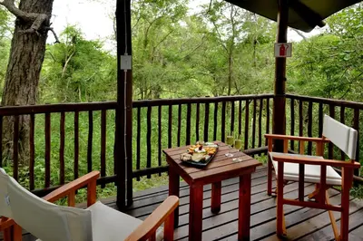 a table and two chairs on a deck at Kruger Safari Lodge in Manyeleti Game Reserve