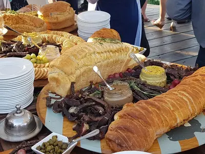 a table topped with a large sandwich and other foods at Stoep Cafe Guest House in Komatipoort