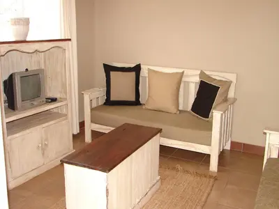 a living room with a couch and a tv at Stoep Cafe Guest House in Komatipoort