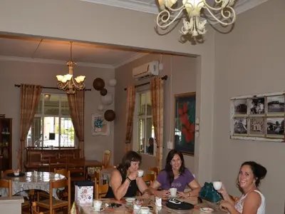 three women sitting at a table in a dining room at Stoep Cafe Guest House in Komatipoort
